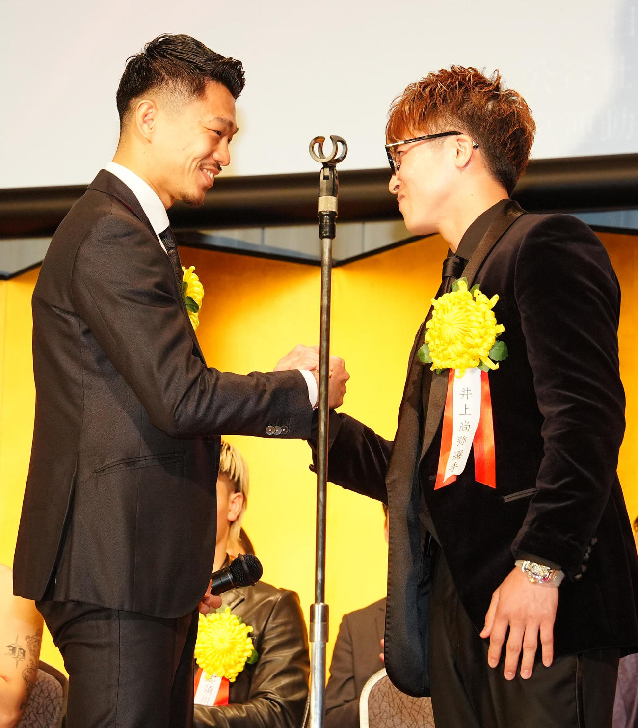 年間表彰式での壇上で、中谷（左）に対戦を呼びかけ、握手を交わす井上尚（撮影・江口和貴）
