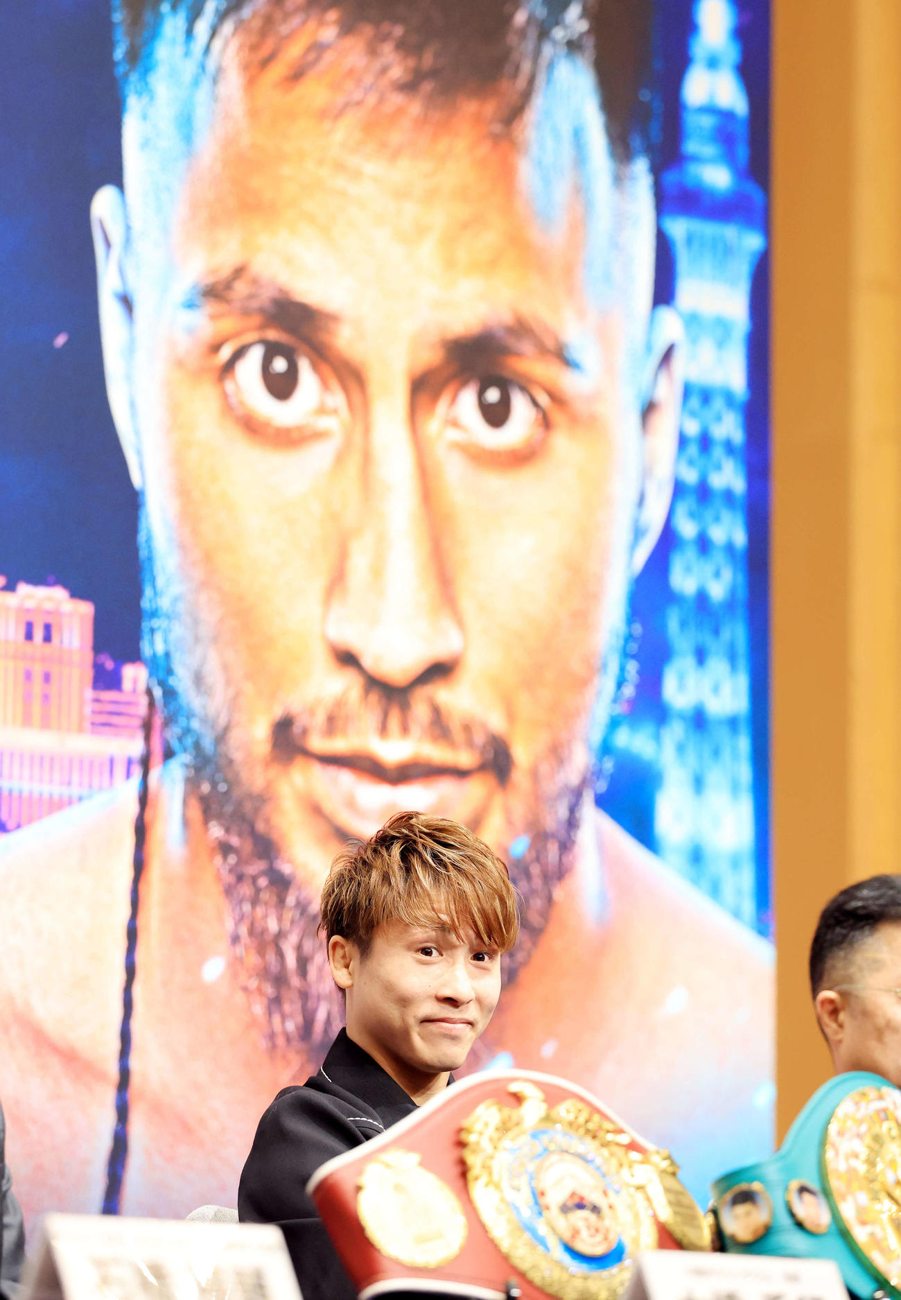 4団体統一世界スーパーバンタム級タイトルマッチ「井上尚弥　in　ラスベガス」の会見で対戦相手のカルデナスの写真を背に笑みを浮かべる井上（撮影・浅見桂子）