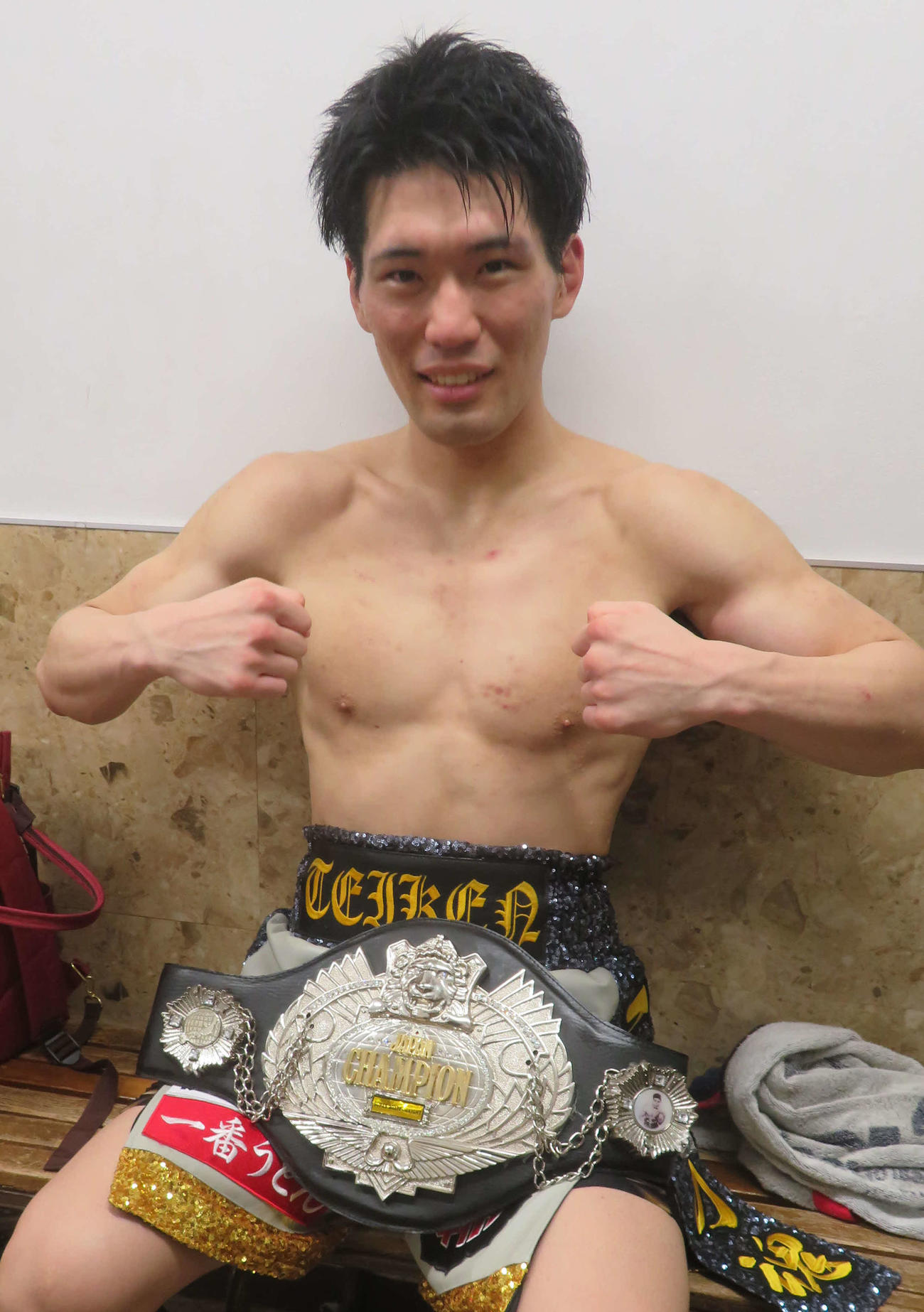 日本スーパーウエルター級王座ベルトを手にして笑顔をみせる豊嶋亮太