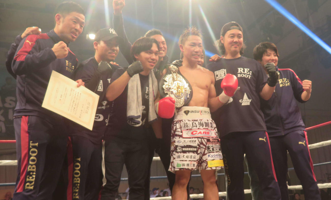 所属ジムの射場哲也会長（左から6人目）らセコンド陣と喜ぶ日本スーパーバンタム級新王者石井渡士也（同4番目）