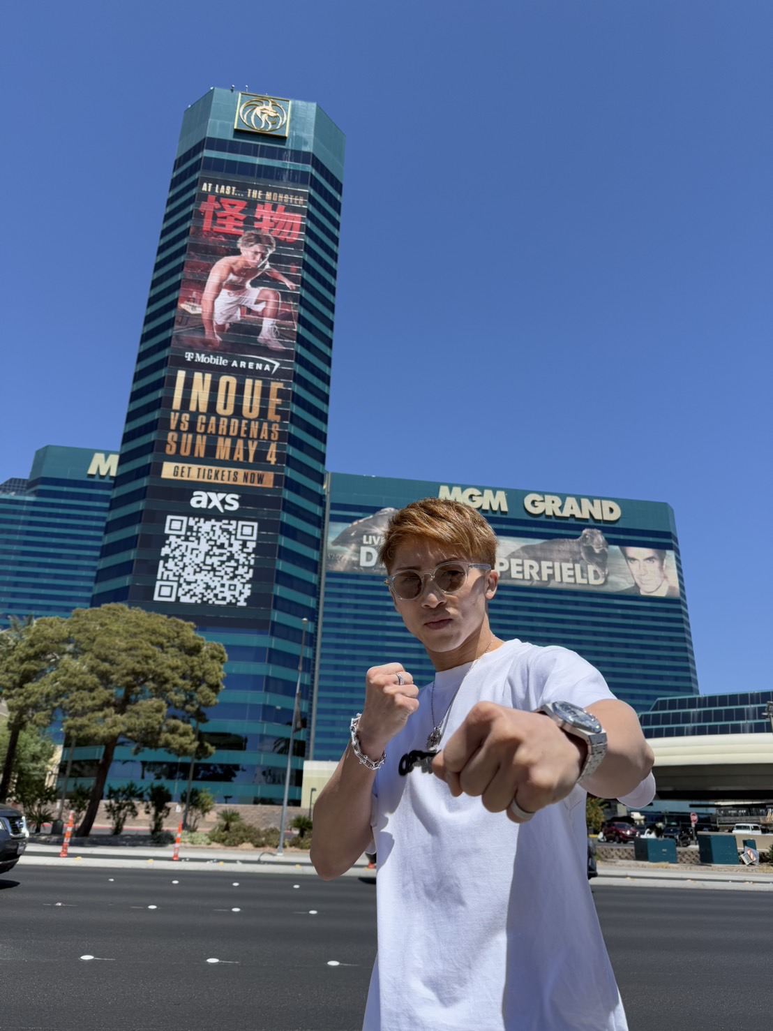 ラスベガスでの調整開始後初のオフとなった井上尚弥はMGMグランドに掲げられた自身の試合PR特大ポスターの前でポーズ（大橋Hジム提供）