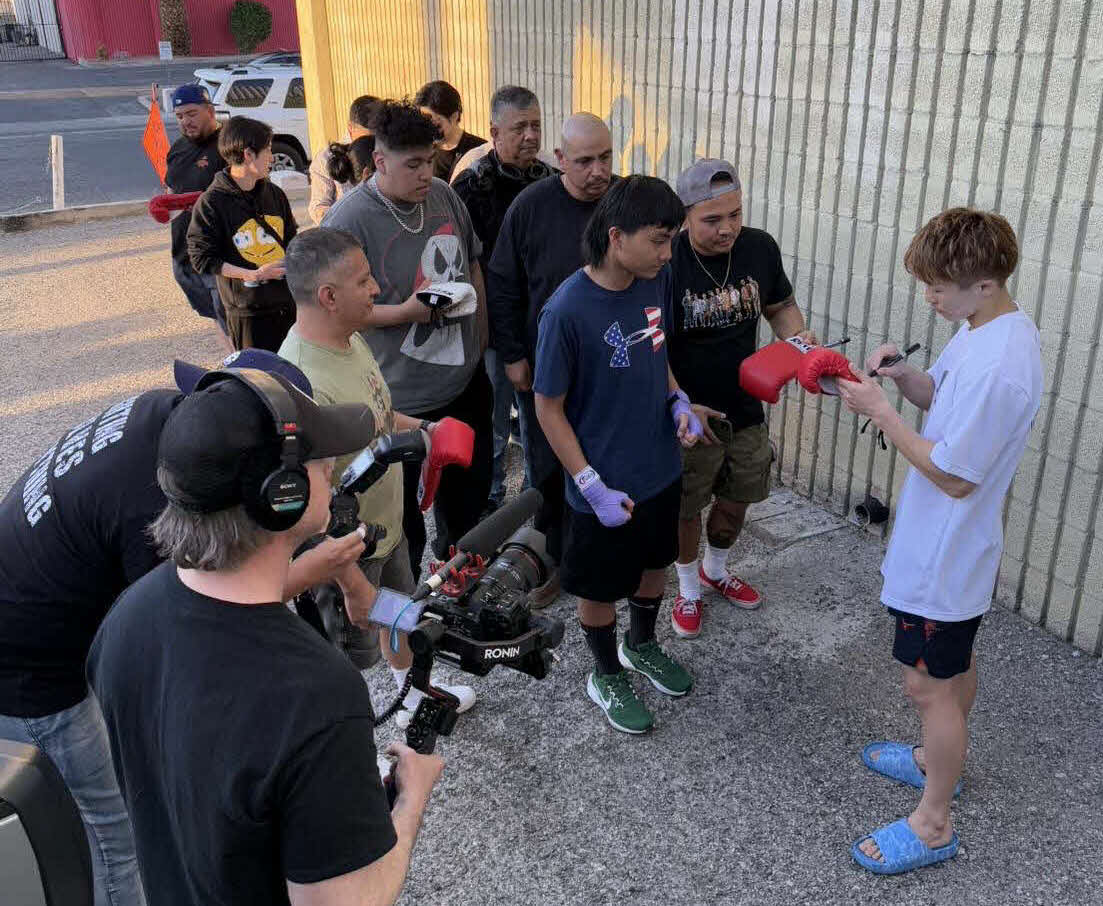 練習後、ジムの外に集まった大勢のファンにサインする井上尚弥（右端）（大橋ジム提供）