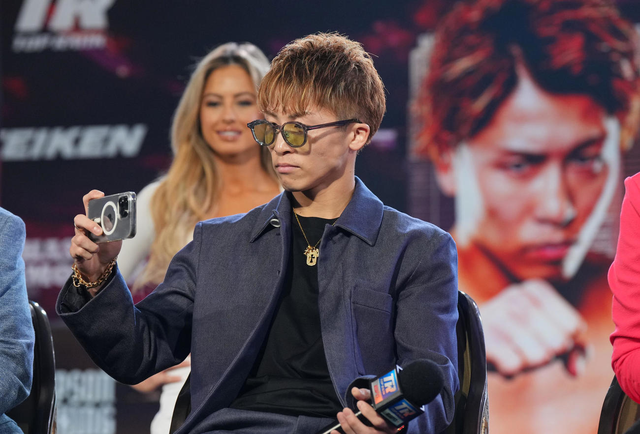 会見場の壇上からスマホで写真を撮る井上（撮影・菅敏）