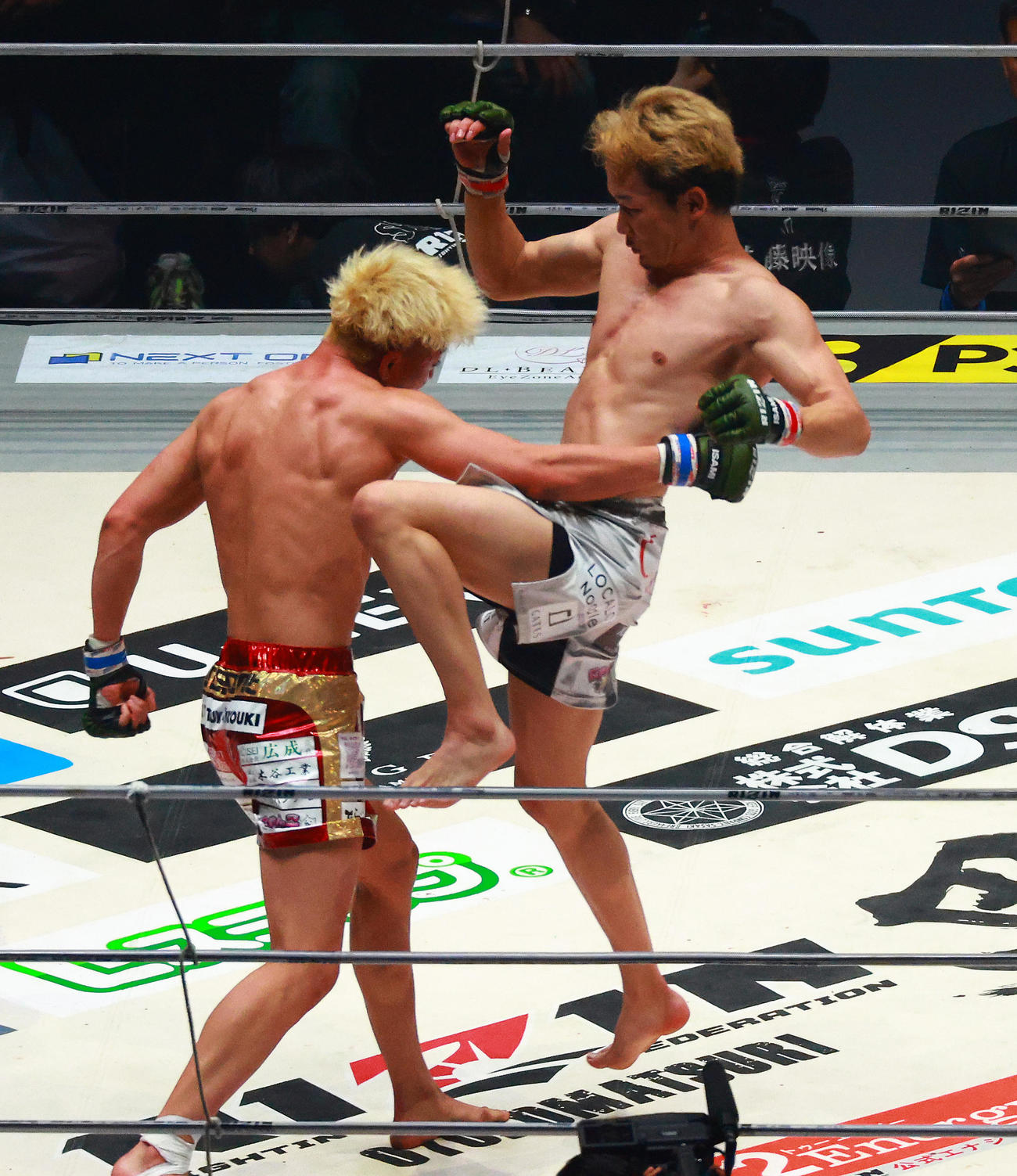 鈴木（左）にジャンピングニーキックを浴びせる朝倉（撮影・中島郁夫）