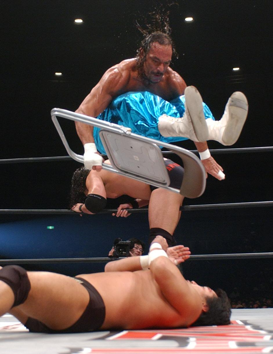 黒田哲広にパイプイスごとボディプレスを仕掛けるサブゥーさん（上）（2004年3月撮影）