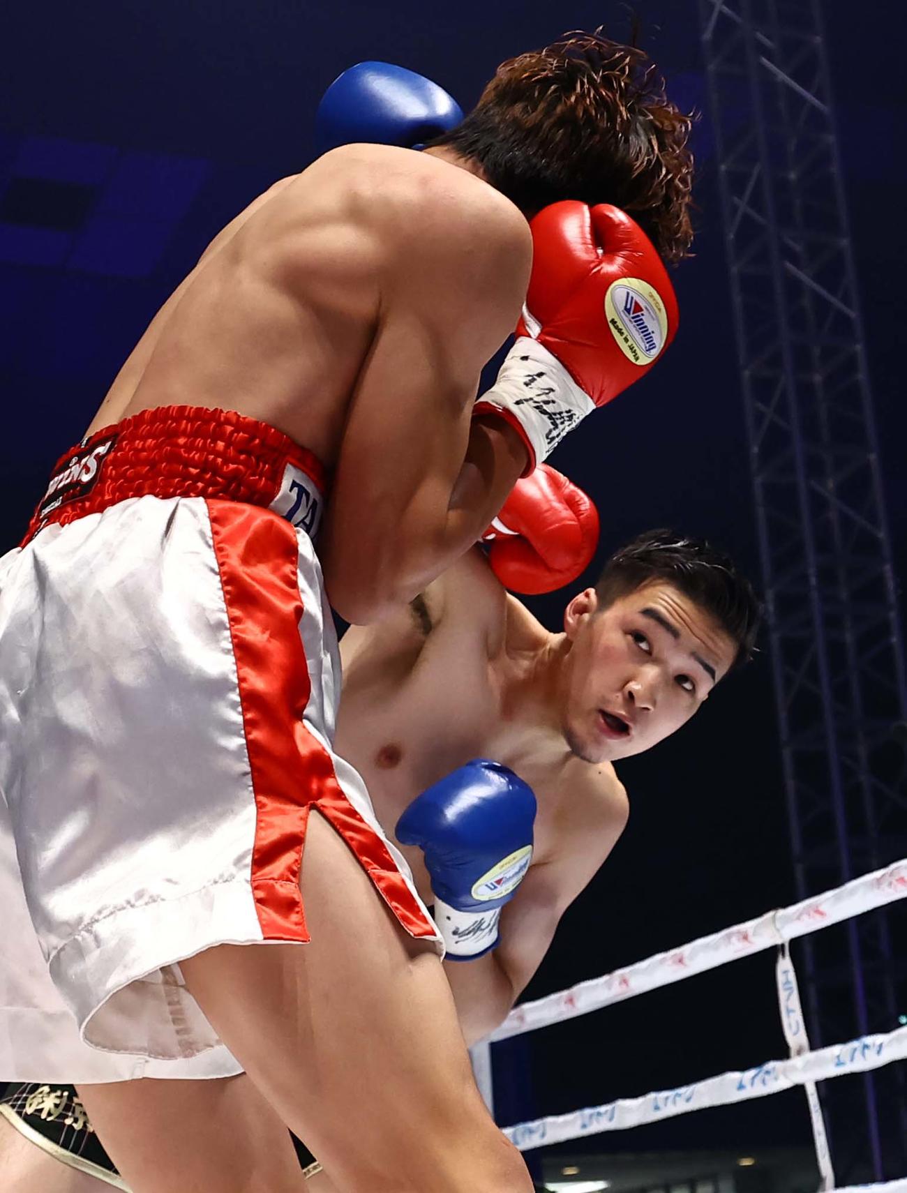 スクリット・ナックプリチャ（左）にパンチを見舞う丸元（撮影・上田博志）
