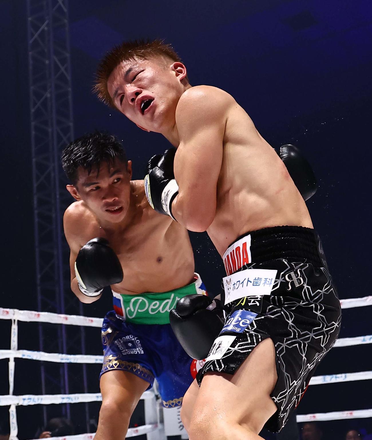 8回、ペドロ・タドゥラン（左）のパンチを浴びる重岡銀次朗（撮影・上田博志）