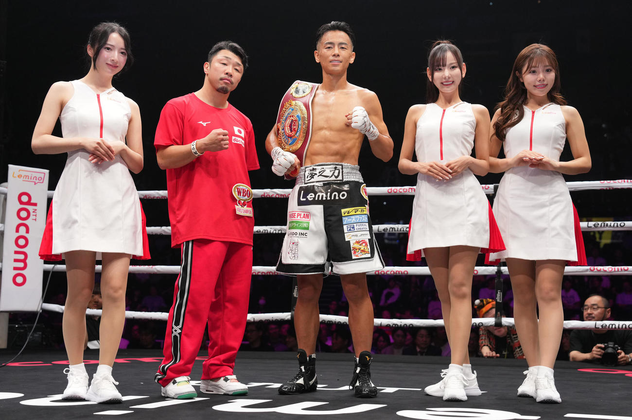 1回TKO勝ちで勝ちした武居（中央）は八重樫トレーナー（左から2人目）と写真に納まる。左からラウンドガールの月野もも、2人おいて小湊美月、夏川いづみ（撮影・鈴木みどり）
