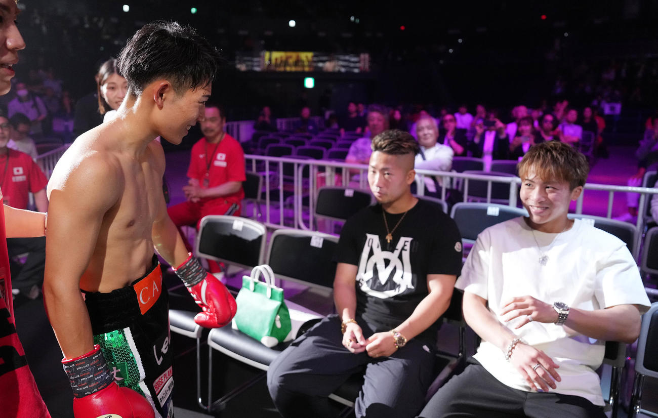 TKO勝ちの荒竹（左）はリングサイドのジムの先輩井上尚（右）と井上拓に笑顔であいさつ（撮影・鈴木みどり）