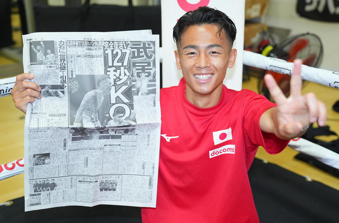WBO世界バンタム級王座防衛一夜明け会見で自身が掲載された日刊スポーツの紙面を手に写真に納まる武居（撮影・垰建太）