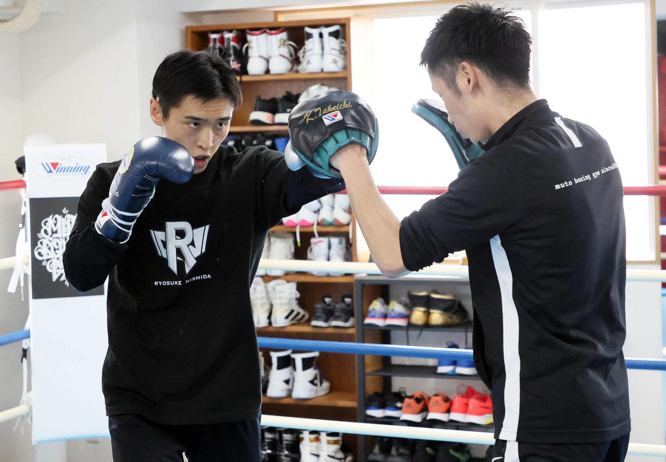 武市晃輔トレーナー（右）を相手にミット打ちする西田凌佑（撮影・宮崎幸一）