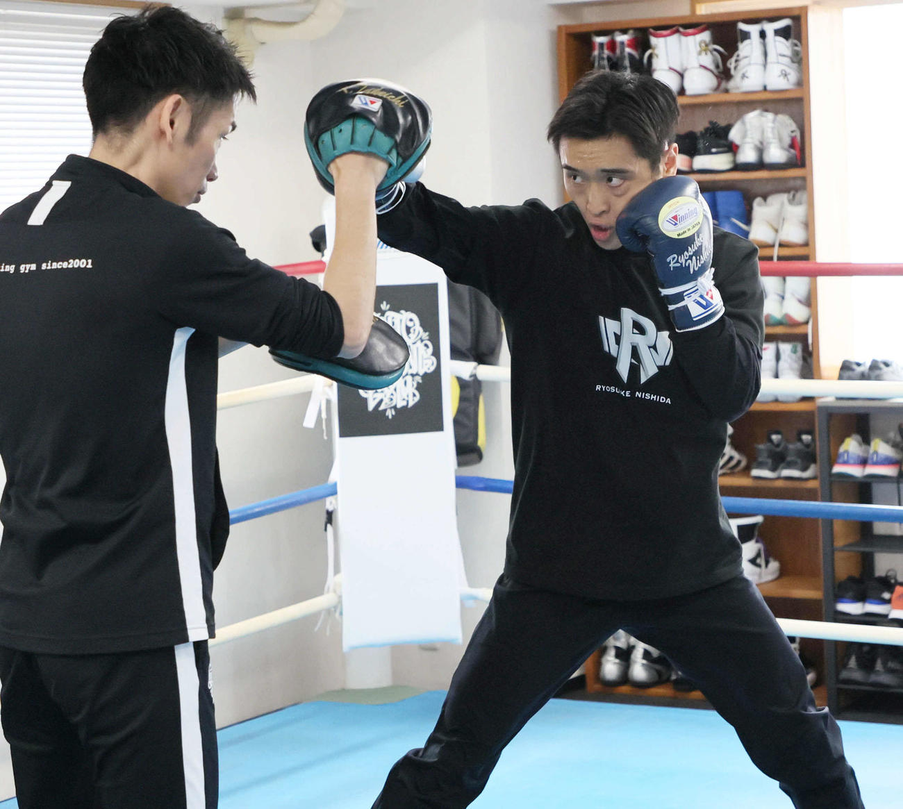武市晃輔トレーナー（左）を相手にミット打ちする西田凌佑（撮影・宮崎幸一）