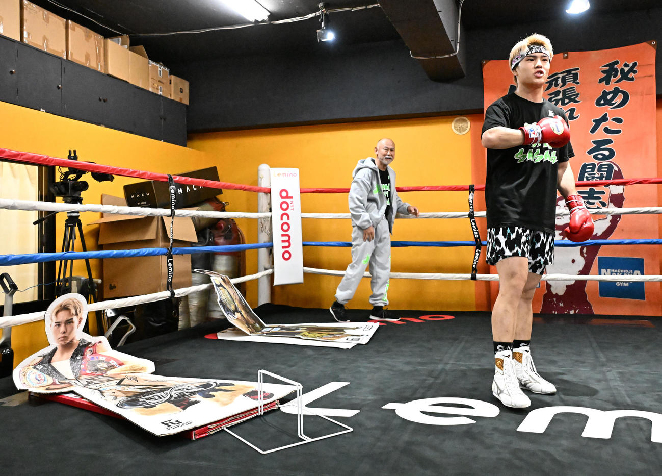 公開練習で、「過去の自分に打ち勝つ」と自身の等身大パネルを倒した佐々木尽。左は中屋広隆チーフトレーナー（撮影・千葉一成）