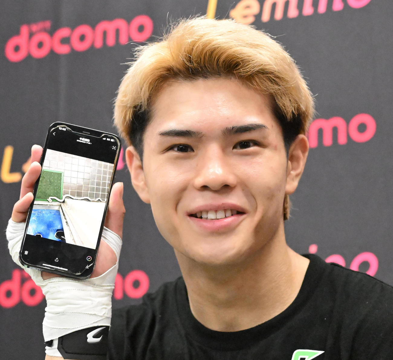 1週間くらい前にジムの前に現れた白ヘビの写真を披露する佐々木尽（撮影・千葉一成）