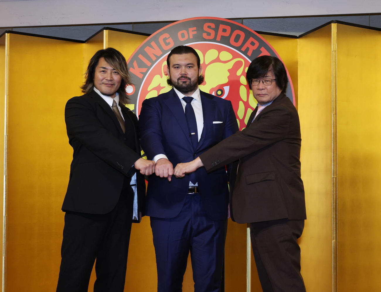 新日本プロレス入団会見で拳を合わせるウルフ・アロン。左は新日本の棚橋弘至社長、右はブシロードの木谷高明社長（撮影・増田悦実）