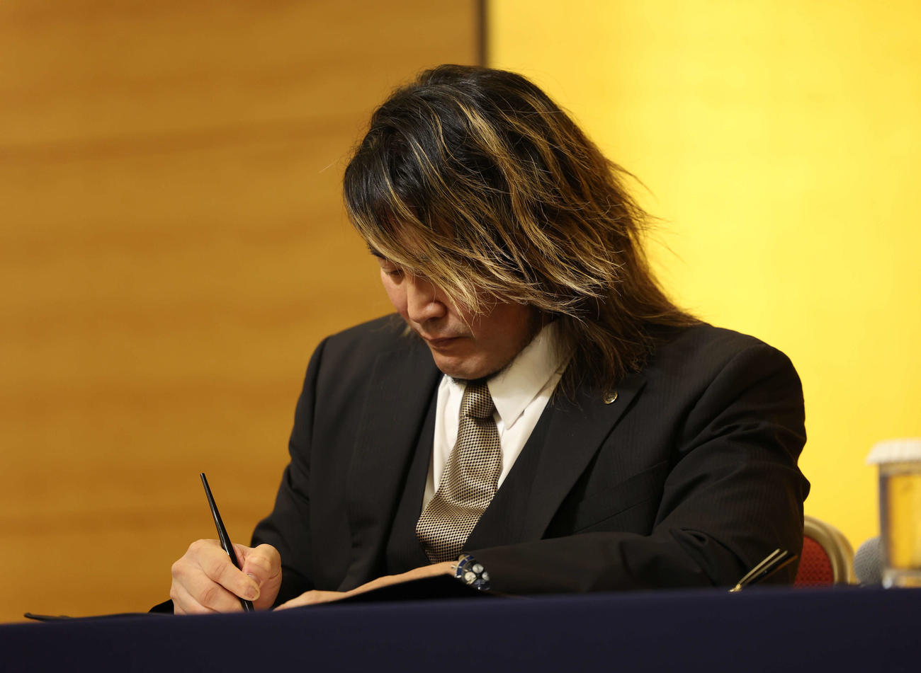 新日本プロレス入団会見で契約書にサインをする新日本の棚橋弘至社長（撮影・増田悦実）