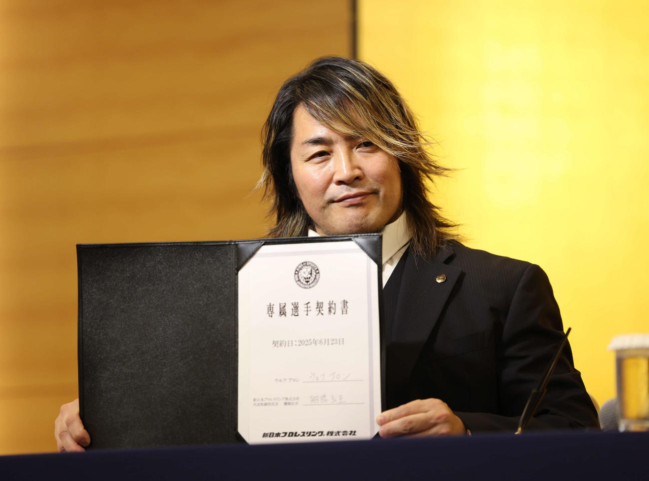 新日本プロレス入団会見でウルフ・アロンのサインが入った契約書見せる新日本の棚橋社長（撮影・増田悦実）