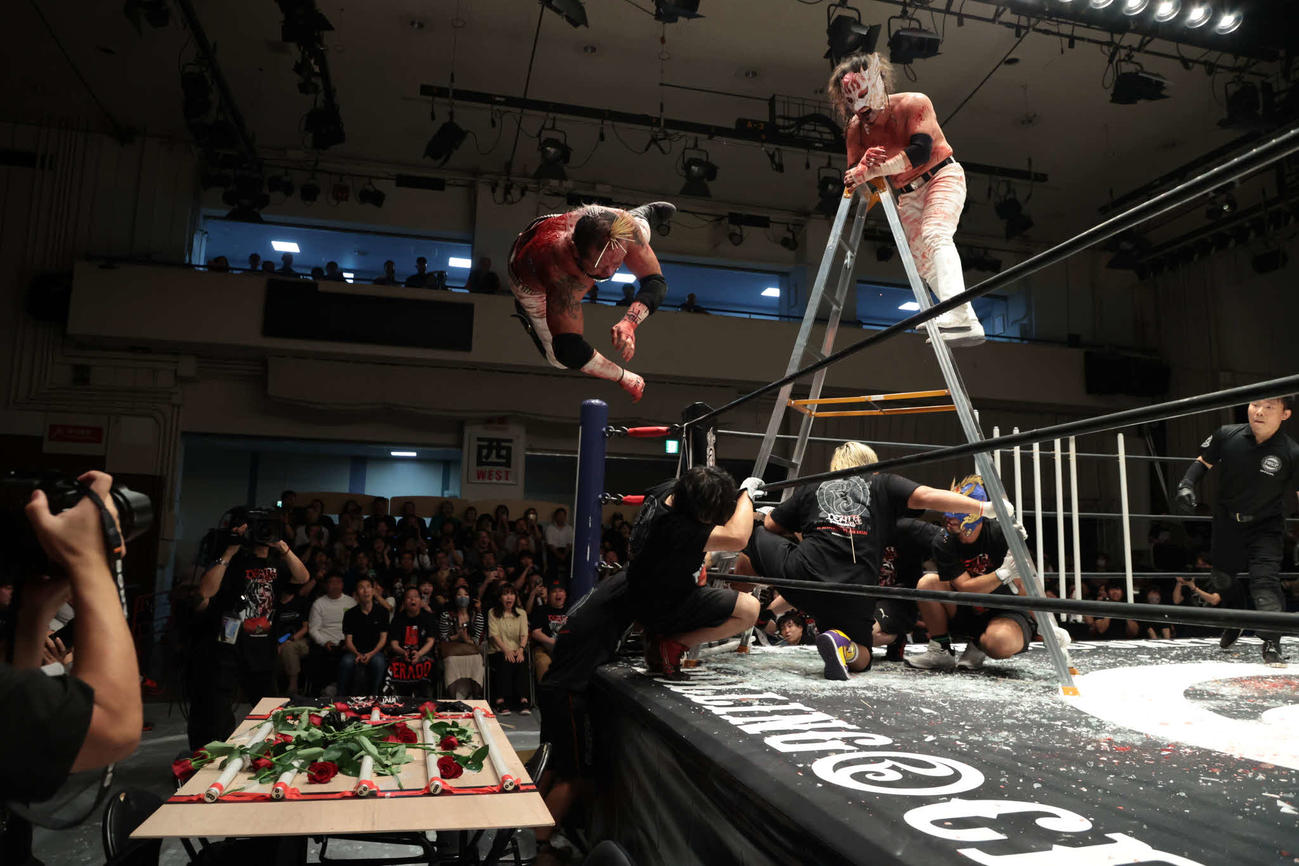 脚立の上から場外の蛍光灯ボードに葛西を突き落としたデスペラード（C）新日本プロレス