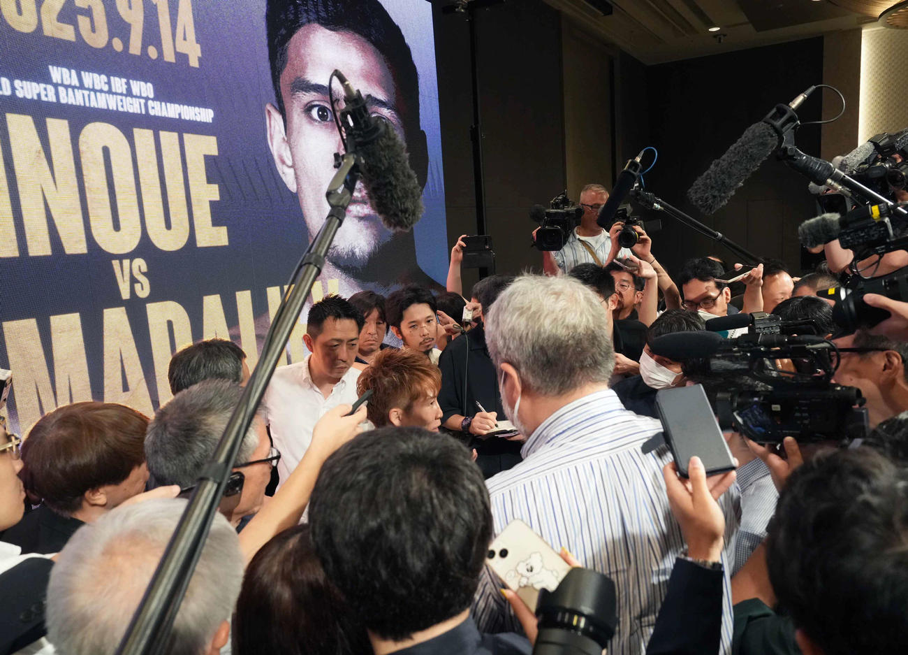 NTTドコモ　presents Lemino BOXINGトリプル世界戦の開催発表記者会見を終えた4団体統一王者の井上尚（中央）は大勢の報道陣に囲まれる（撮影・小沢裕）