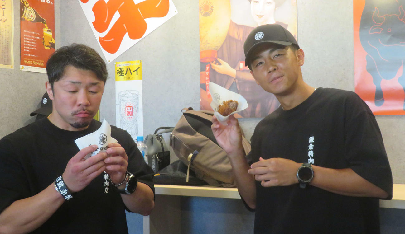 鎌倉精肉店の名物メンチカツを試食するWBO世界バンタム級王者武居由樹（右）と八重樫東トレーナー