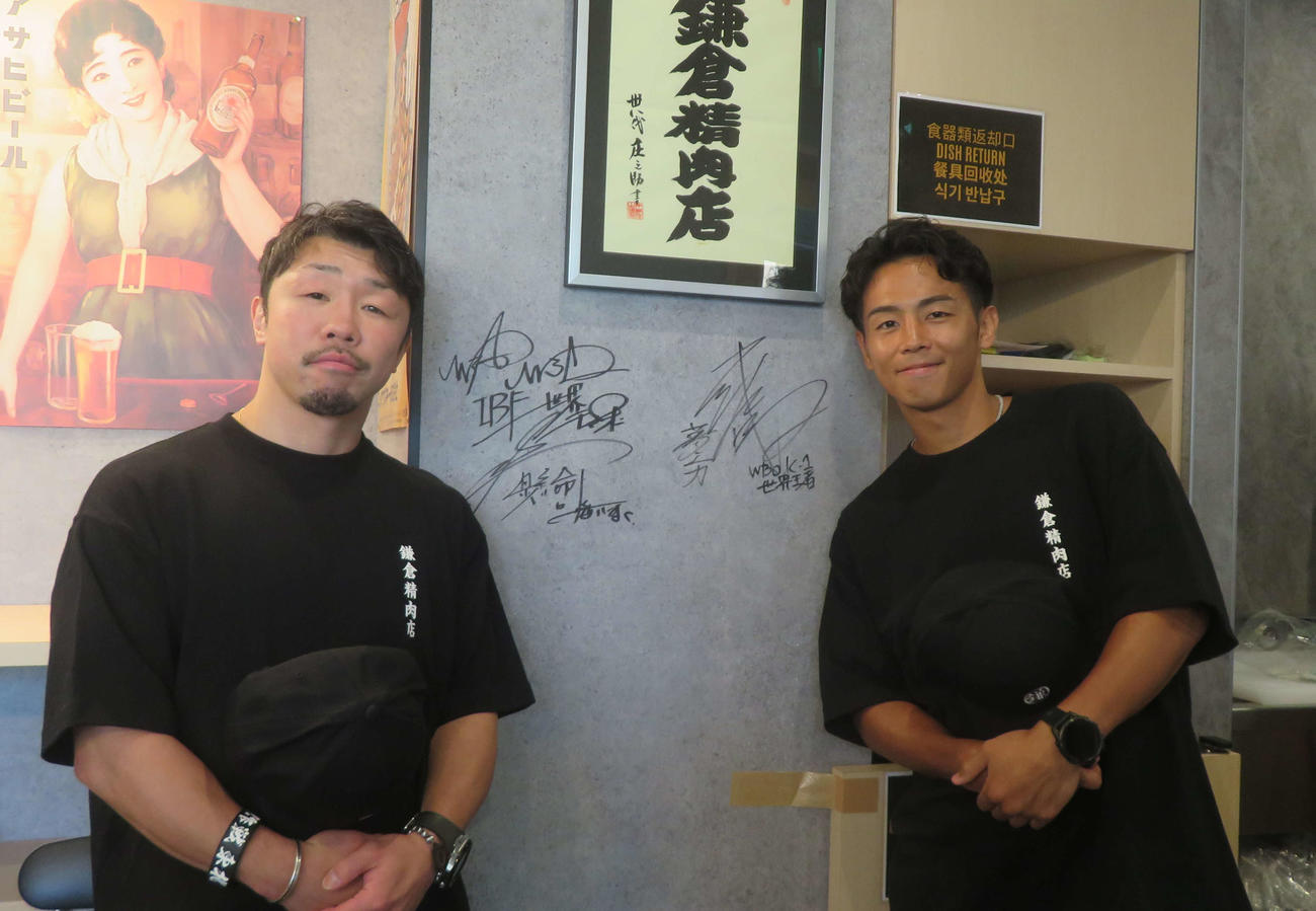 1日店長を務めた鎌倉精肉店内にサインしたWBO世界バンタム級王者武居由樹（右）と八重樫東トレーナー