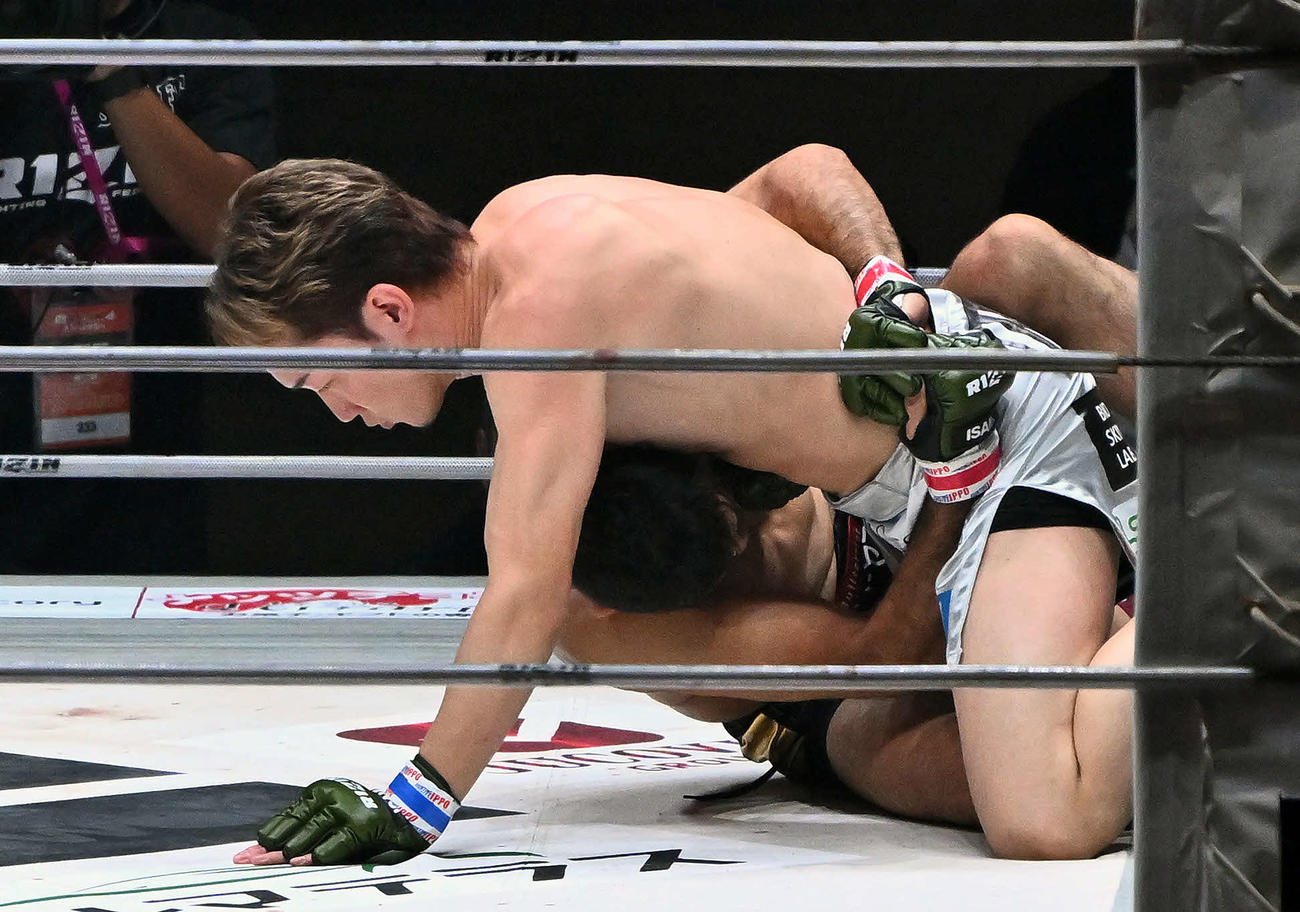 1回、グラウンドの攻防で朝倉はクレベル・コイケの上になる（撮影・滝沢徹郎）　