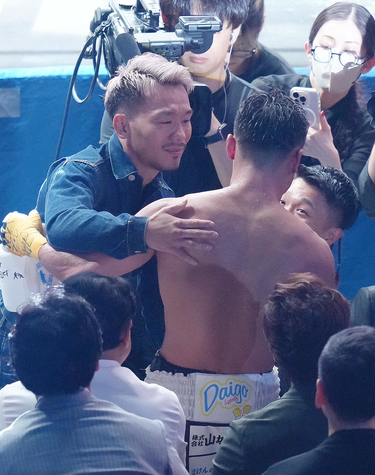 バルガスと引き分けに終わった比嘉（右）と抱き合う堤（撮影・足立雅史）