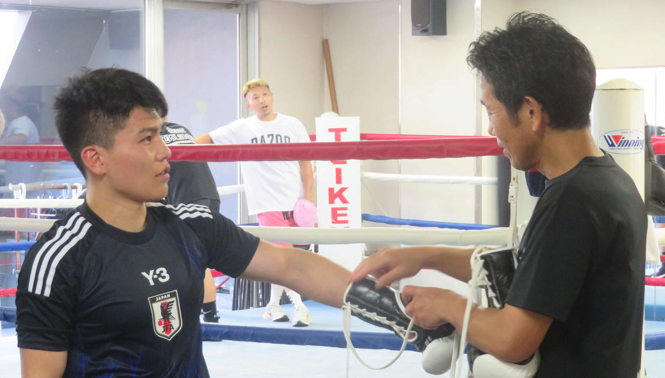 田中繊大トレーナー（右）と話し合うWBOアジア・パシフィック・バンタム級王者の坪井智也