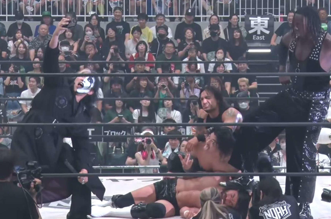 モリス（下）をリンチした後、記念写真を撮るチーム2000Xの（左から）ヨシ・タツ、OZAWA、ダガ、ヌル（レッスルユニバース配信から）