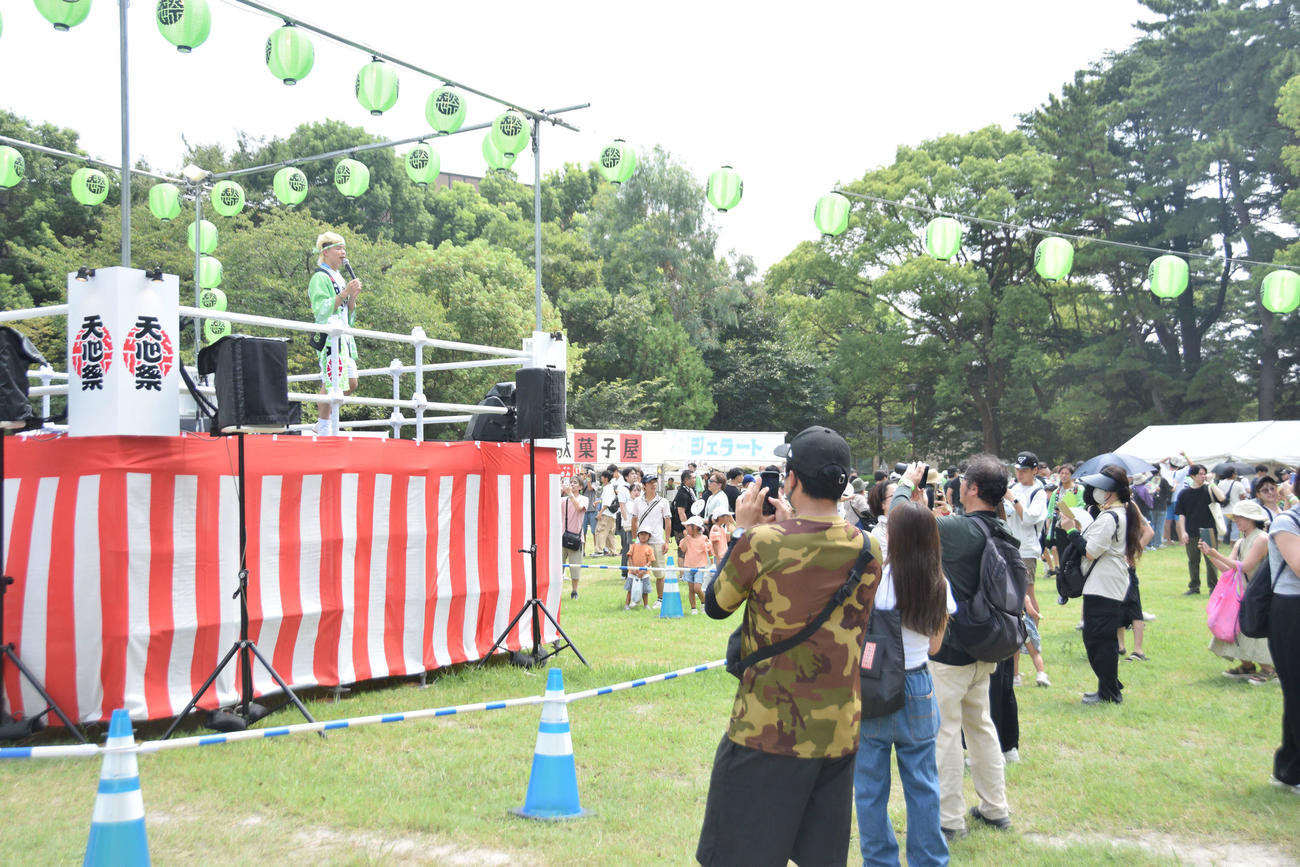 やぐらの上から出店屋台を紹介する那須川天心と集まる人たち（撮影・泉光太郎）