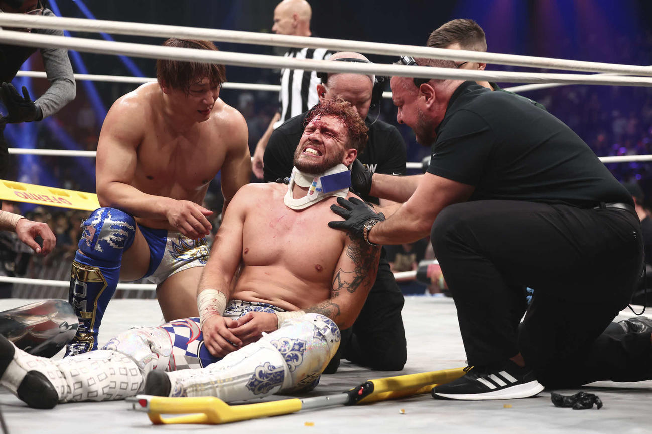 モクスリーにリンチされ、立てなくなったオスプレイ（中央）を心配そうに見守る飯伏幸太（左）（C）新日本プロレス