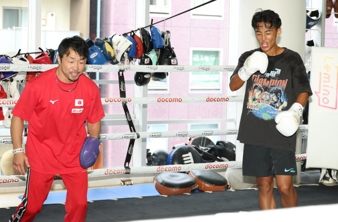 八重樫トレーナー（左）のミットを飛ばし、笑顔を見せるWBO世界バンタム級王者の武居（撮影・中島郁夫）