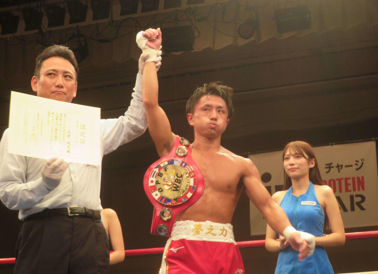 2度目防衛に成功し、勝ち名乗りを受ける東洋太平洋ミニマム級王者石井武志（中央）