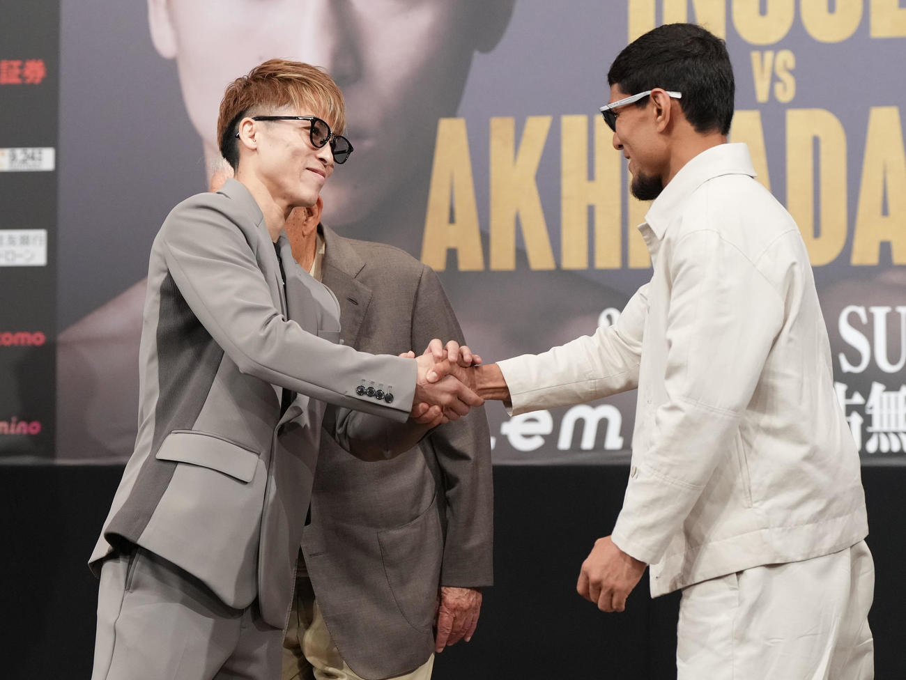 会見後、握手を交わす井上（左）とアフマダリエフ（撮影・森本幸一）