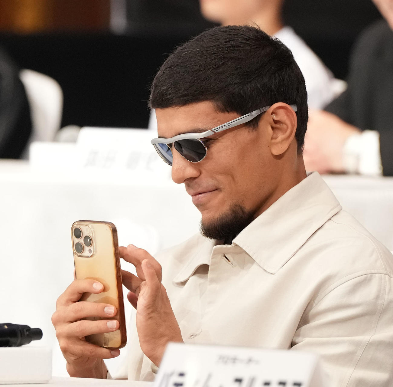 スマホを触るアフマダリエフ（撮影・森本幸一）