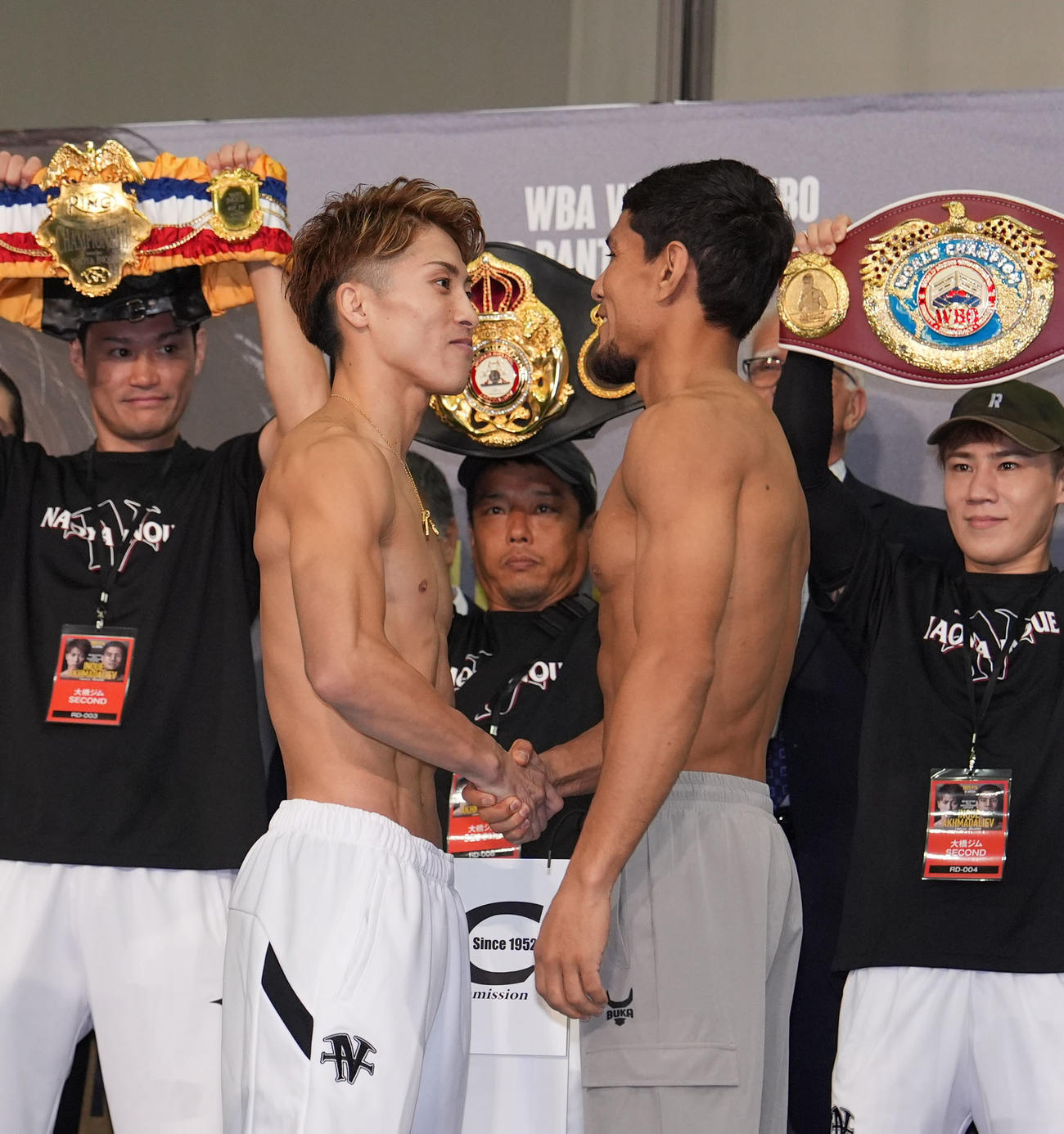 井上（前列・左）は前日計量をクリアしアフマダリエフと握手を交わす（撮影・森本幸一）