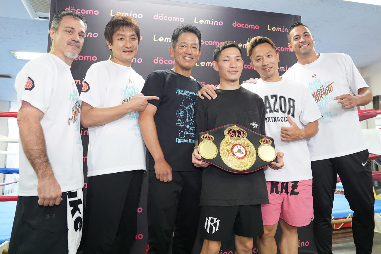 一夜明け会見を終え、トレーナーたちと笑顔で写真に納まるWBA世界ミニマム級王者の松本（左から4人目）。左からオギー・サンチェス・トレーナー、大和トレーナー、田中トレーナー、1人おいて粟生トレーナー、カルロス・リナレス・トレーナー（撮影・鈴木みどり）