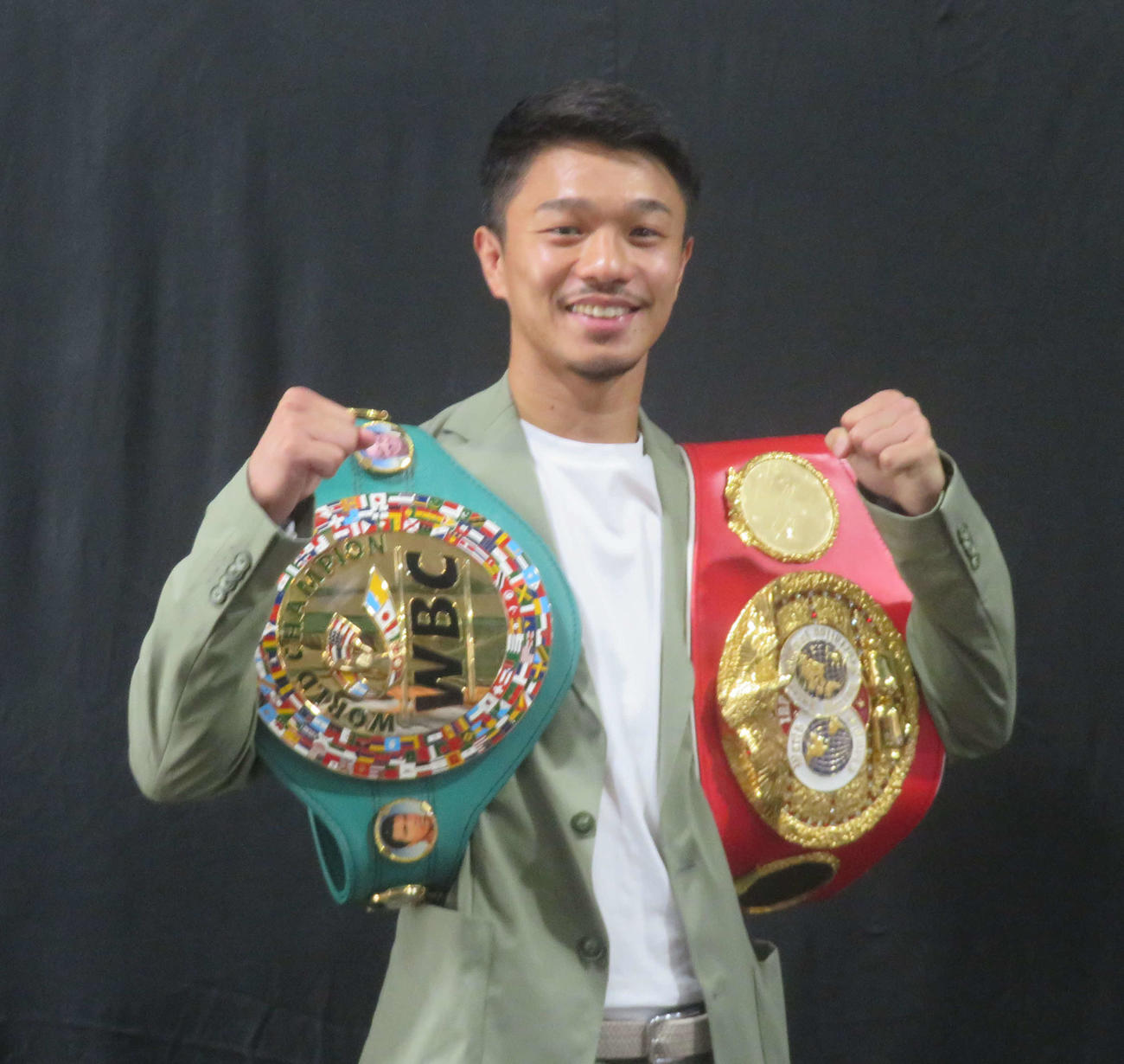 最後のお披露目となるWBC、IBF世界バンタム級ベルトを肩にかけて写真撮影に対応する中谷潤人