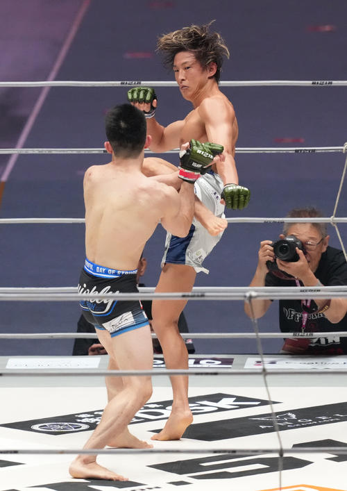 2回、小林(右)は佐藤執にキックを放つ(撮影・森本幸一)