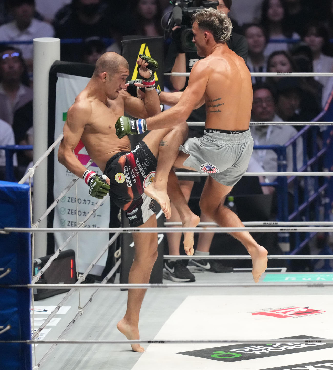 1回、佐藤将（左）はサバテロと膝蹴りを打ち合う（撮影・森本幸一）