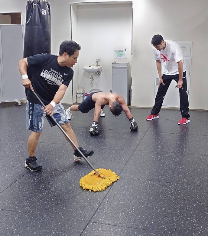 鈴木康弘トレーナー（右端）、北野良トレーナー（左端）のもと、腕立て伏せする井上拓真（大橋ジム提供）