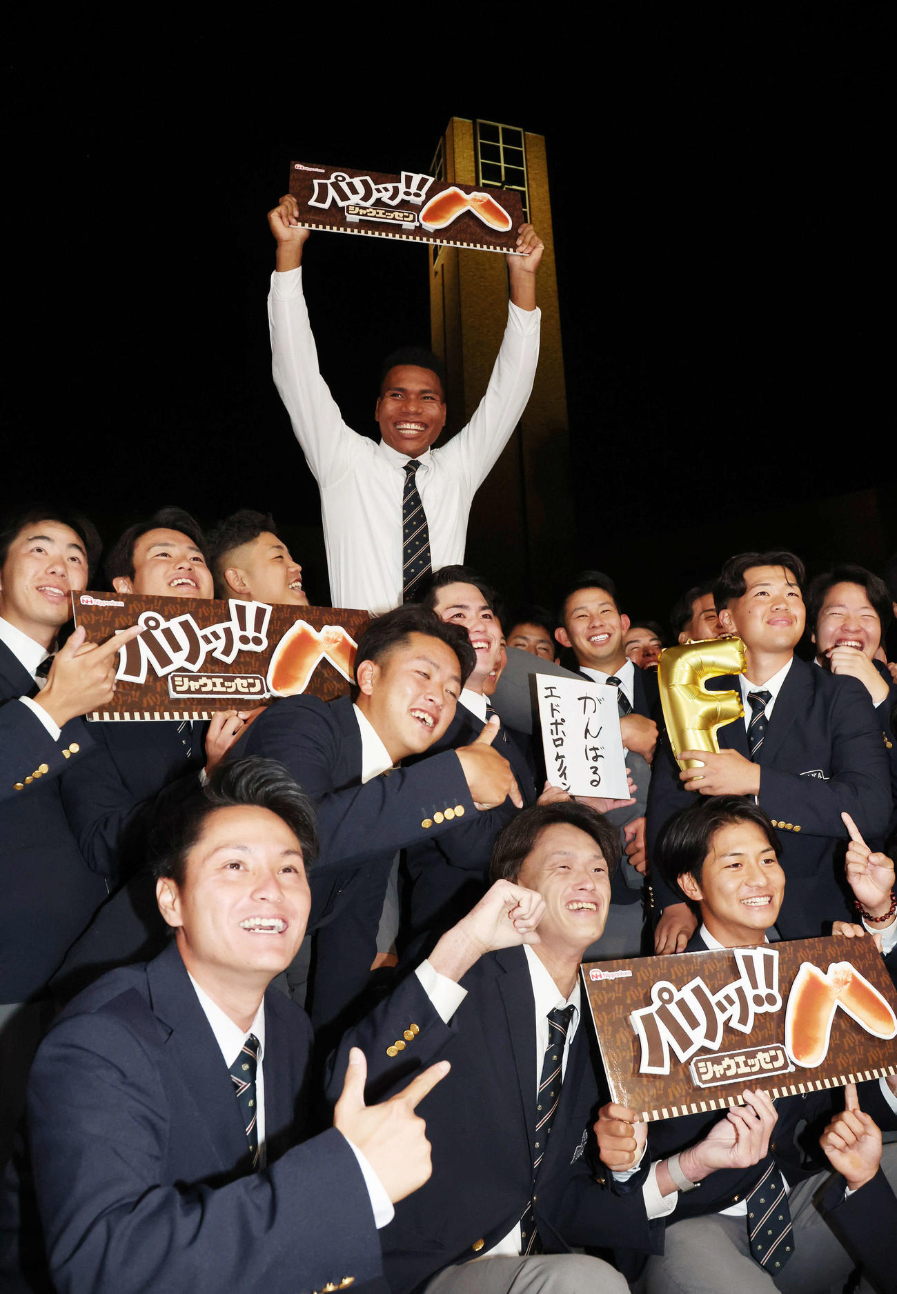 日本ハム2位の大阪学院大エドポロ・ケイン（中）は野球部員に担がれ笑顔を見せる（撮影・西尾就之）