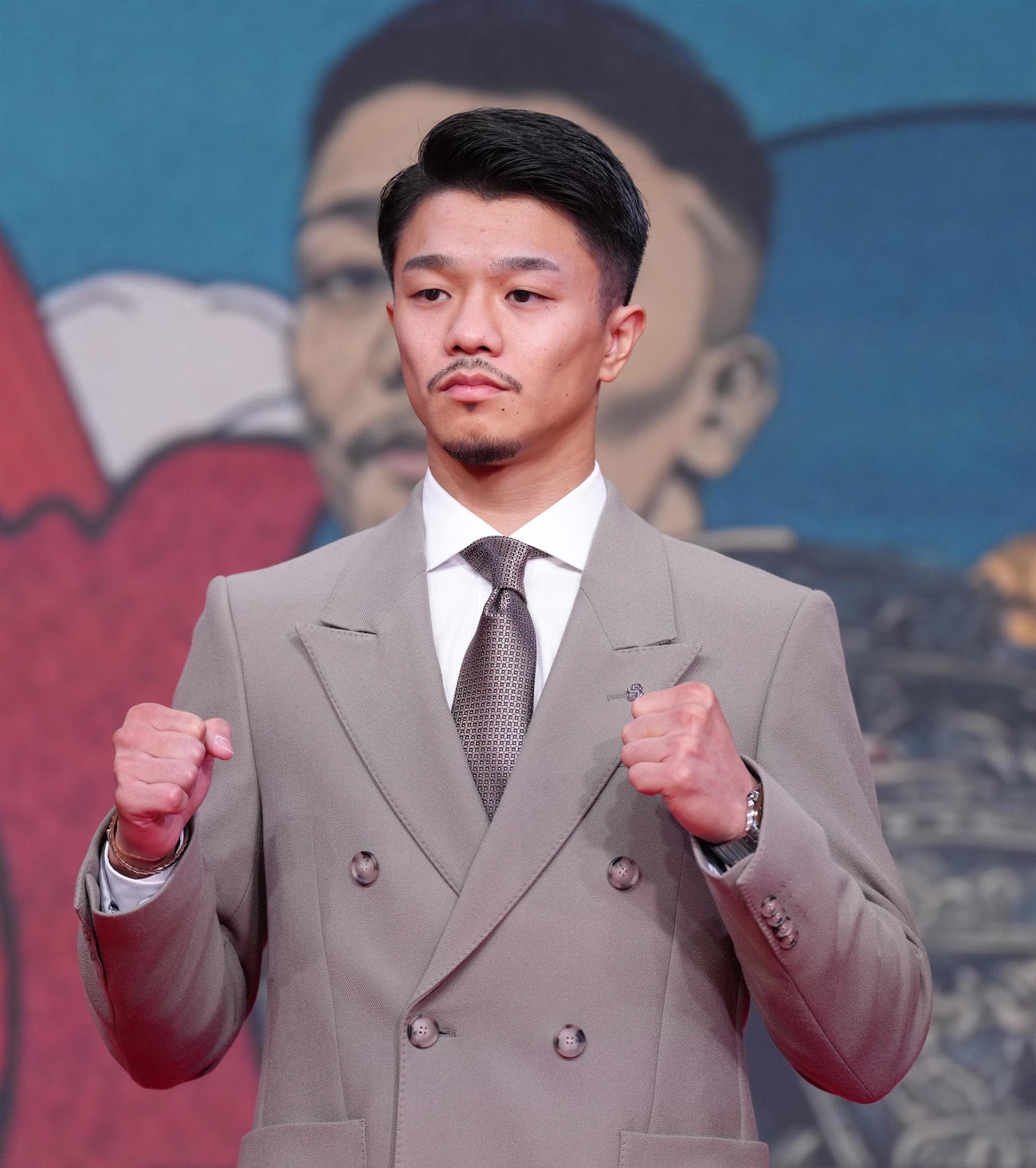 会見に登場しポーズを決める中谷（撮影・足立雅史）