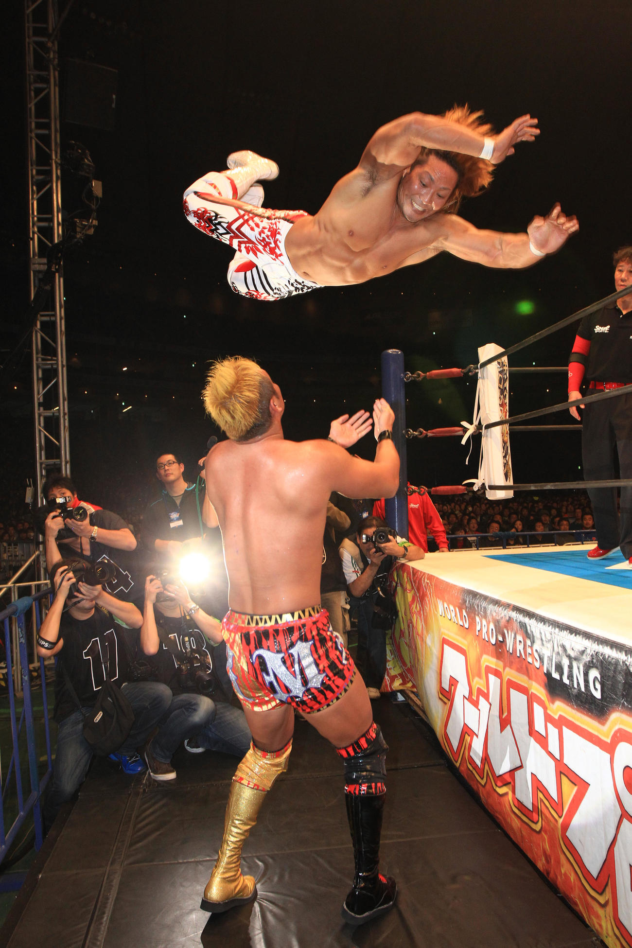 新日本東京ドーム大会　棚橋弘至対オカダ・カズチカ　IWGPヘビー級選手権　鉄柱からオカダ・カズチカにハイフライフローを浴びせる棚橋弘至＝2013年1月4日