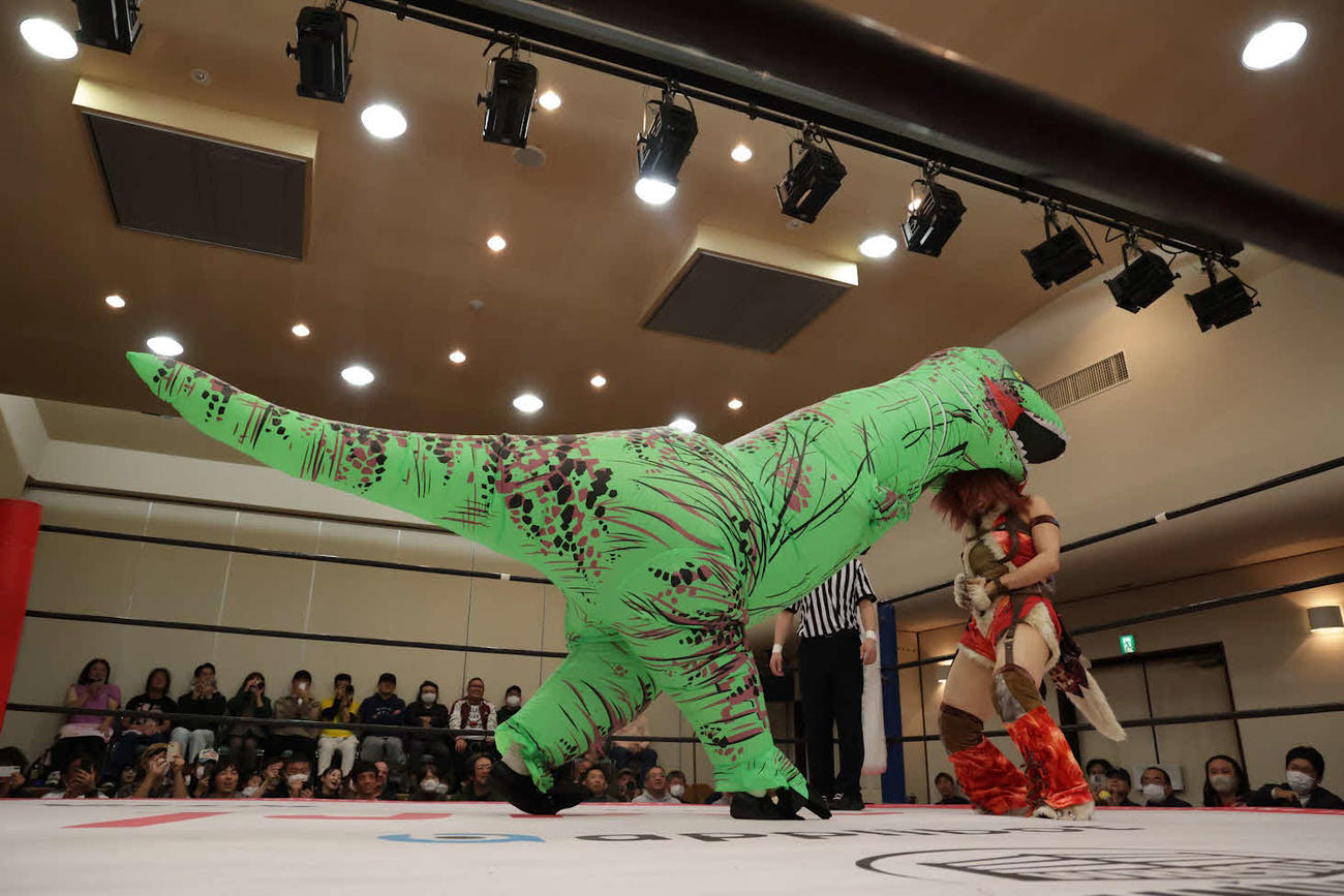 ティラノサウルスのコスチュームで中島翔子を攻撃する原宿ぽむ
