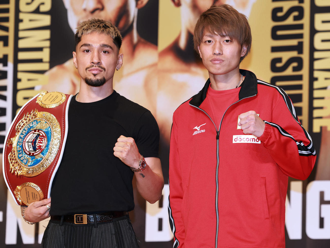 会見でガッツポーズのWBO世界フライ級王者のオラスクアガ（左）と挑戦者の桑原（撮影・野上伸悟）