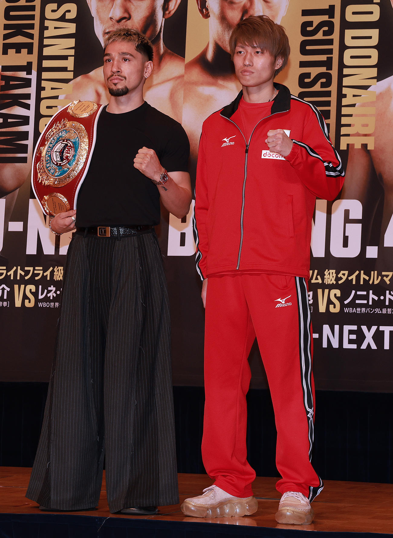 会見でガッツポーズのWBO世界フライ級王者のオラスクアガ（左）と挑戦者の桑原（撮影・野上伸悟）