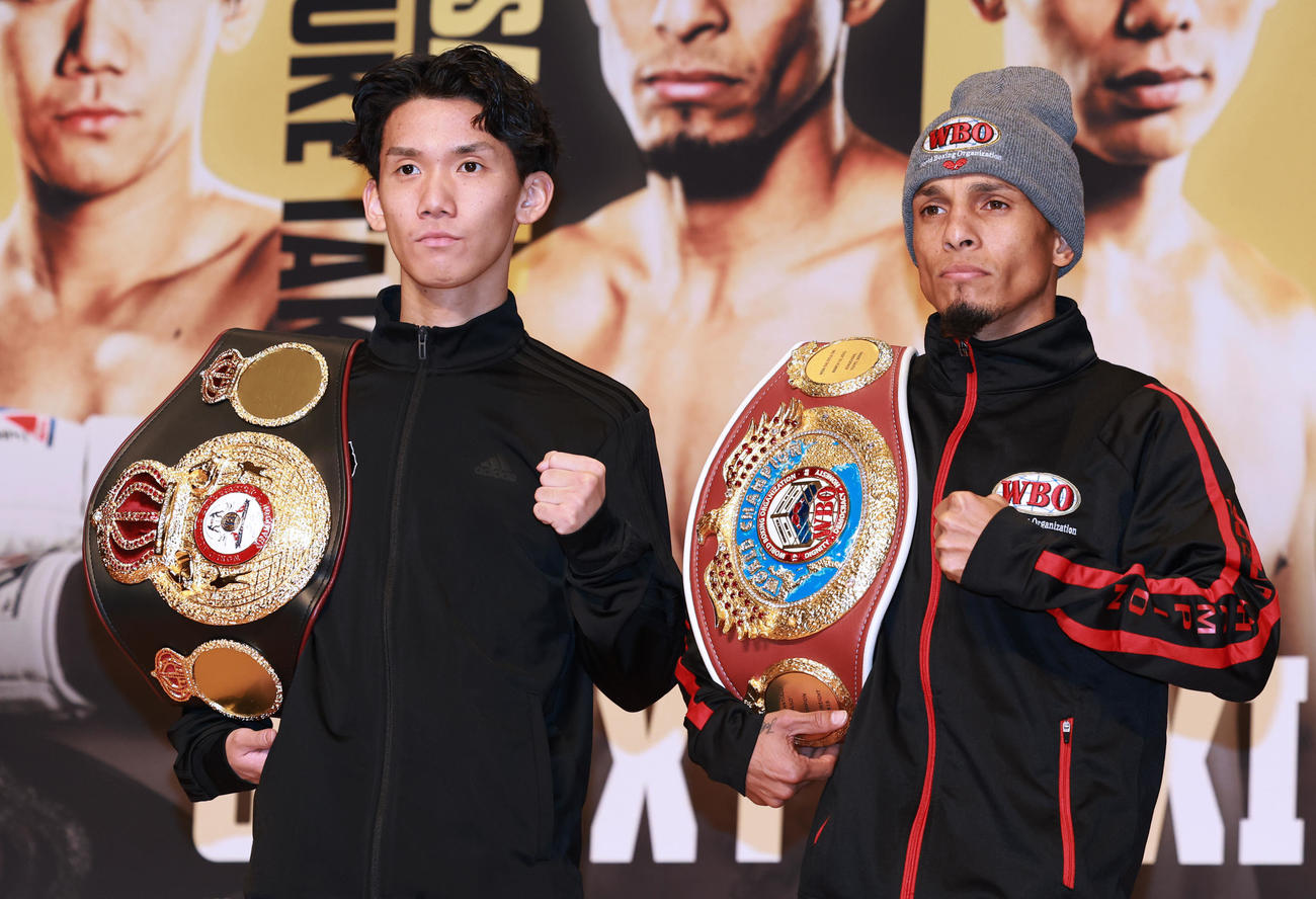 会見でファイティングポーズのWBA世界ライトフライ級王者の高見（左）WBO世界ライトフライ級王者のサンティアゴ（撮影・野上伸悟）