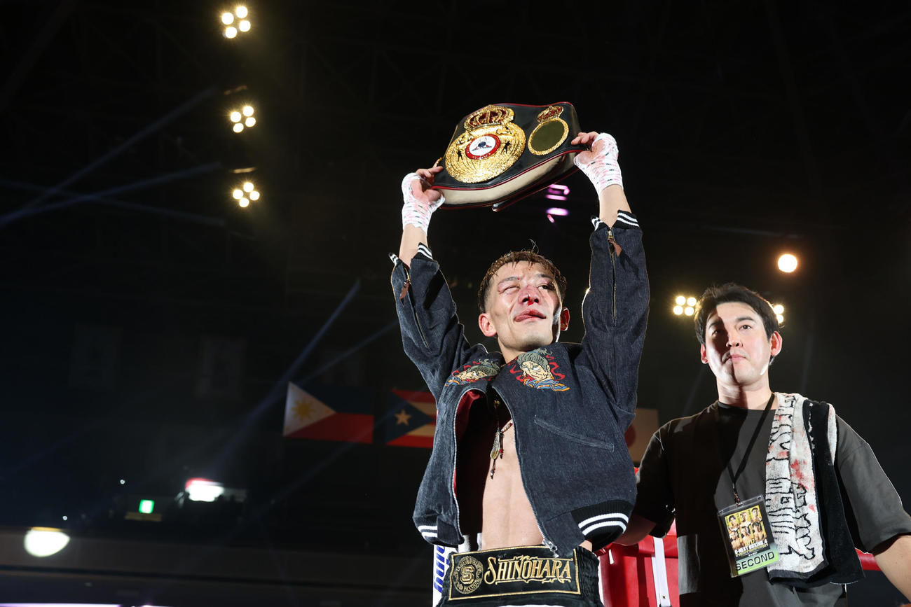 統一王者に輝きベルトを掲げる堤（左）。右は石原トレーナー（撮影・宮地輝）