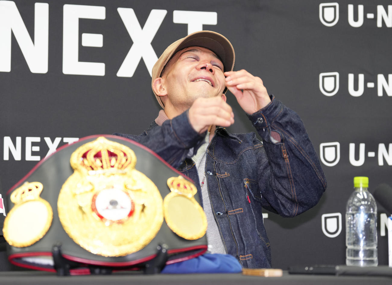 一夜明け会見中、笑顔を見せながら痛がる堤（撮影・足立雅史）